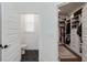 Contemporary bathroom with hexagonal floor tiles, leading to a well-organized walk-in closet at 15408 Lebeau Loop, Winter Garden, FL 34787