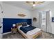 Comfortable bedroom with a blue accent wall, ceiling fan, and natural light at 15408 Lebeau Loop, Winter Garden, FL 34787