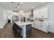 Modern kitchen with white cabinets, stainless steel appliances, an island with bar stool seating, and pendant lighting at 15408 Lebeau Loop, Winter Garden, FL 34787