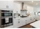Well-equipped kitchen with built-in stainless appliances, white cabinetry, granite countertops, and modern fixtures at 15408 Lebeau Loop, Winter Garden, FL 34787