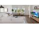 Bright living room with hardwood floors, white sofa, accent chairs, and large windows providing ample natural light at 15408 Lebeau Loop, Winter Garden, FL 34787