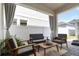 Charming covered patio with stylish outdoor furniture and privacy screening at 15408 Lebeau Loop, Winter Garden, FL 34787