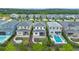 Aerial view of backyards with manicured lawns, landscaped gardens, stone paver patios, and swimming pools at 15702 Vetta Dr, Bella Collina, FL 34756