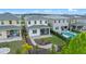 Aerial view of the backyard featuring a stone paver patio, manicured lawn, garden, and swimming pool at 15702 Vetta Dr, Bella Collina, FL 34756