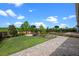 Well-manicured backyard featuring stone paver patio, lush grass, and manicured landscaping at 15702 Vetta Dr, Bella Collina, FL 34756