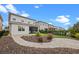 Beautiful backyard featuring a manicured lawn, landscaped garden, and a spacious stone paver patio at 15702 Vetta Dr, Bella Collina, FL 34756