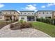 Beautiful backyard featuring a manicured lawn, landscaped garden, and a spacious stone paver patio at 15702 Vetta Dr, Bella Collina, FL 34756