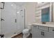 Modern bathroom features a glass-enclosed shower, toilet, grey vanity with a white countertop, and wood tile flooring at 15702 Vetta Dr, Bella Collina, FL 34756