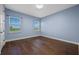 Bright bedroom features hardwood floors, two windows, and light blue walls at 15702 Vetta Dr, Bella Collina, FL 34756