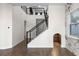 Lovely interior entryway features dark wood floors, black railings, a half staircase, and unique nook under the stairs at 15702 Vetta Dr, Bella Collina, FL 34756