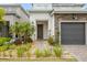 Charming home showcasing a landscaped front yard, stone accents, and a covered front entryway at 15702 Vetta Dr, Bella Collina, FL 34756