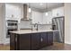 Modern kitchen featuring an island, pendant lights, stainless steel appliances, and white cabinets at 15702 Vetta Dr, Bella Collina, FL 34756