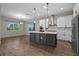 Modern kitchen featuring a large island with stainless steel appliances and pendant lighting at 15702 Vetta Dr, Bella Collina, FL 34756