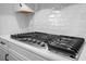 Stainless steel gas range cooktop is set against a white subway tile backsplash at 15702 Vetta Dr, Bella Collina, FL 34756