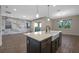 Contemporary kitchen island boasts a sink and stylish fixtures under modern pendant lighting at 15702 Vetta Dr, Bella Collina, FL 34756