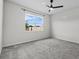 Bright bedroom with gray carpet, ceiling fan, and a window providing natural light at 1773 Groveline Rd, St Cloud, FL 34771