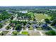 Aerial view of the neighborhood with houses and surrounding greenery, including a pond at 1857 E Cooper Dr, Deltona, FL 32725