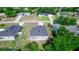 Aerial view of a home and its neighborhood, showcasing rooflines, yards and surrounding trees at 1857 E Cooper Dr, Deltona, FL 32725