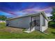 Exterior view of the home's screened in patio and backyard with lush green grass at 1857 E Cooper Dr, Deltona, FL 32725