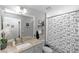 Neutral bathroom with a patterned shower curtain, sink, and large mirror and white flowers at 1857 E Cooper Dr, Deltona, FL 32725