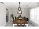 Elegant dining room with a modern chandelier, wooden table, and a window for natural light at 1857 E Cooper Dr, Deltona, FL 32725
