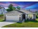 Charming single-story home with gray exterior, well-manicured lawn, and two-car garage at 1857 E Cooper Dr, Deltona, FL 32725
