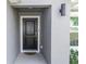 Inviting front entrance featuring a classic black door, modern lighting, and neutral gray walls at 1857 E Cooper Dr, Deltona, FL 32725