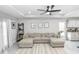 Comfortable living room with a large sectional sofa, stylish rug, and bright, neutral aesthetic at 1857 E Cooper Dr, Deltona, FL 32725
