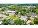 An aerial view of the property shows a home surrounded by lush greenery and a red outline emphasizing the property boundaries at 201 W Washington St, Minneola, FL 34715