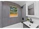Updated bathroom featuring a tub, window, grey tile, and modern vanity at 205 W Princeton St, Orlando, FL 32804