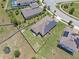 Aerial view of the home with a fenced yard and solar panels in a residential area at 209 Luxmore Rd, Groveland, FL 34736