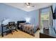 Bedroom with light blue walls, desk, and a window with backyard views at 209 Luxmore Rd, Groveland, FL 34736