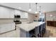 Bright eat-in kitchen featuring stainless appliances, white cabinetry, and a large island with bar stool seating at 209 Luxmore Rd, Groveland, FL 34736