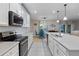 Beautiful kitchen with stainless steel appliances, modern countertops, and a view into the adjacent dining area at 209 Luxmore Rd, Groveland, FL 34736