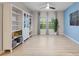 Inviting living space boasting a white bookcase, light wood floors, large windows with curtains, and an accent wall at 209 Luxmore Rd, Groveland, FL 34736