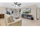 Comfortable living room featuring wood floors, a ceiling fan, a wall-mounted TV, and stylish furniture at 209 Luxmore Rd, Groveland, FL 34736