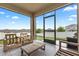 Spacious screened patio featuring neutral tile and wood furniture, ideal for outdoor living at 209 Luxmore Rd, Groveland, FL 34736
