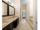 Bright bathroom featuring double vanity with granite countertops and dark wood cabinets and tile flooring at 215 Juniper Ridge Ct, Sanford, FL 32771