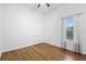 Bright, empty bedroom features hardwood floors, a ceiling fan, and a large window at 215 Juniper Ridge Ct, Sanford, FL 32771