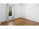 Empty bedroom showcasing hardwood floors and a window with sheer curtains at 215 Juniper Ridge Ct, Sanford, FL 32771