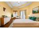 Bright main bedroom featuring a tray ceiling, French doors, and modern furnishings at 215 Juniper Ridge Ct, Sanford, FL 32771
