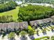An aerial view shows well-maintained townhomes near green space and a pond at 2153 Cypress Villas Dr, Orlando, FL 32825