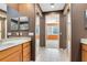 Bright bathroom featuring double sinks with wood cabinets, tiled floors, and a shower visible through frameless glass door at 2153 Cypress Villas Dr, Orlando, FL 32825