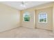 Bright bedroom with neutral walls, carpet floors, a ceiling fan and two windows with views of the greenery at 2153 Cypress Villas Dr, Orlando, FL 32825