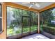 Enclosed lanai offering a serene view of the lush backyard with mature trees and a grassy lawn at 2153 Cypress Villas Dr, Orlando, FL 32825