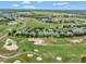 Aerial view of residential homes bordering the golf course with mature landscaping at 23820 Sardinia Dr, Sorrento, FL 32776