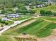 An aerial view of the golf course driving range, clubhouse and practice greens surrounded by mature trees at 23820 Sardinia Dr, Sorrento, FL 32776