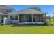View of back exterior and screened in porch overlooking well-kept backyard at 23820 Sardinia Dr, Sorrento, FL 32776