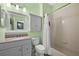 Bathroom with granite-topped vanity, mirrored cabinet, and a tub/shower combination at 23820 Sardinia Dr, Sorrento, FL 32776
