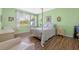 Cozy bedroom featuring a four-poster bed, light-colored furniture, and ample natural light at 23820 Sardinia Dr, Sorrento, FL 32776